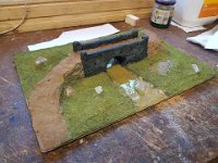 20200525 143855  The grass soused in Camoshade, then dry-brushed with Green Leather - and the epoxy poured for the river. Three whole tubes! The bridge doused in Nuln Oil.